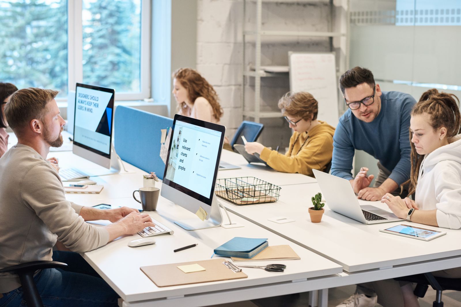 Medical billing team collaborating at computers on revenue cycle workflows